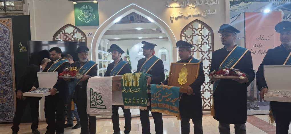پرچم‌گردانی خادمان جمکران در نمایشگاه کتاب به‌مناسبت میلاد امام رضا (ع)